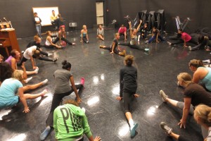 Color Guard team stretching for warm-ups before practice. Photo Credit: Kaitlin Baker-Carr