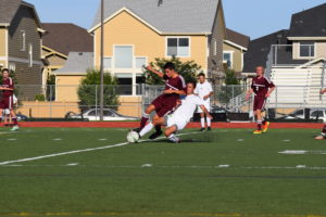 Midfielder, Grant Martinez slide tackles opponent. Photo Credit: Haley Rockwell