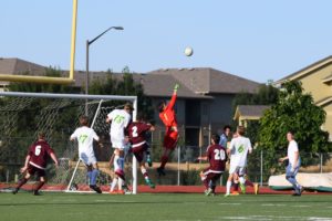 Keeper, Logan Wette punches away the ball off a corner kick. Photo Credit: Haley Rockwell